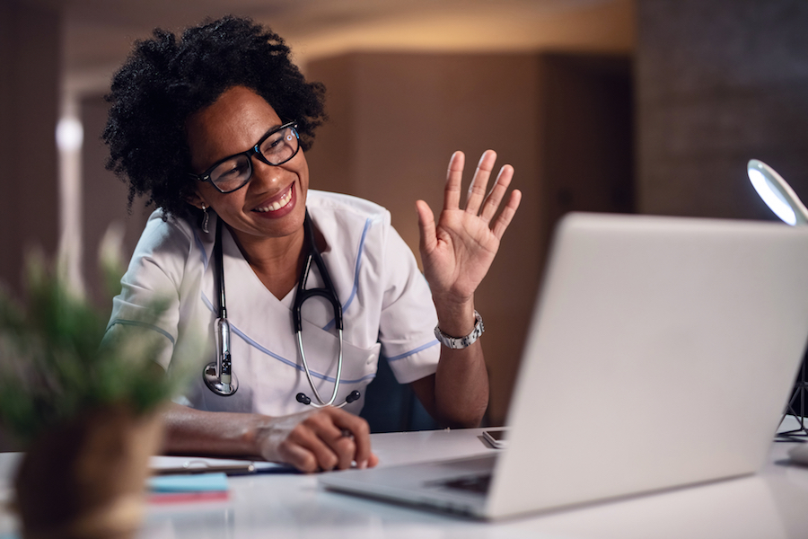 doctor waving at computer screen
